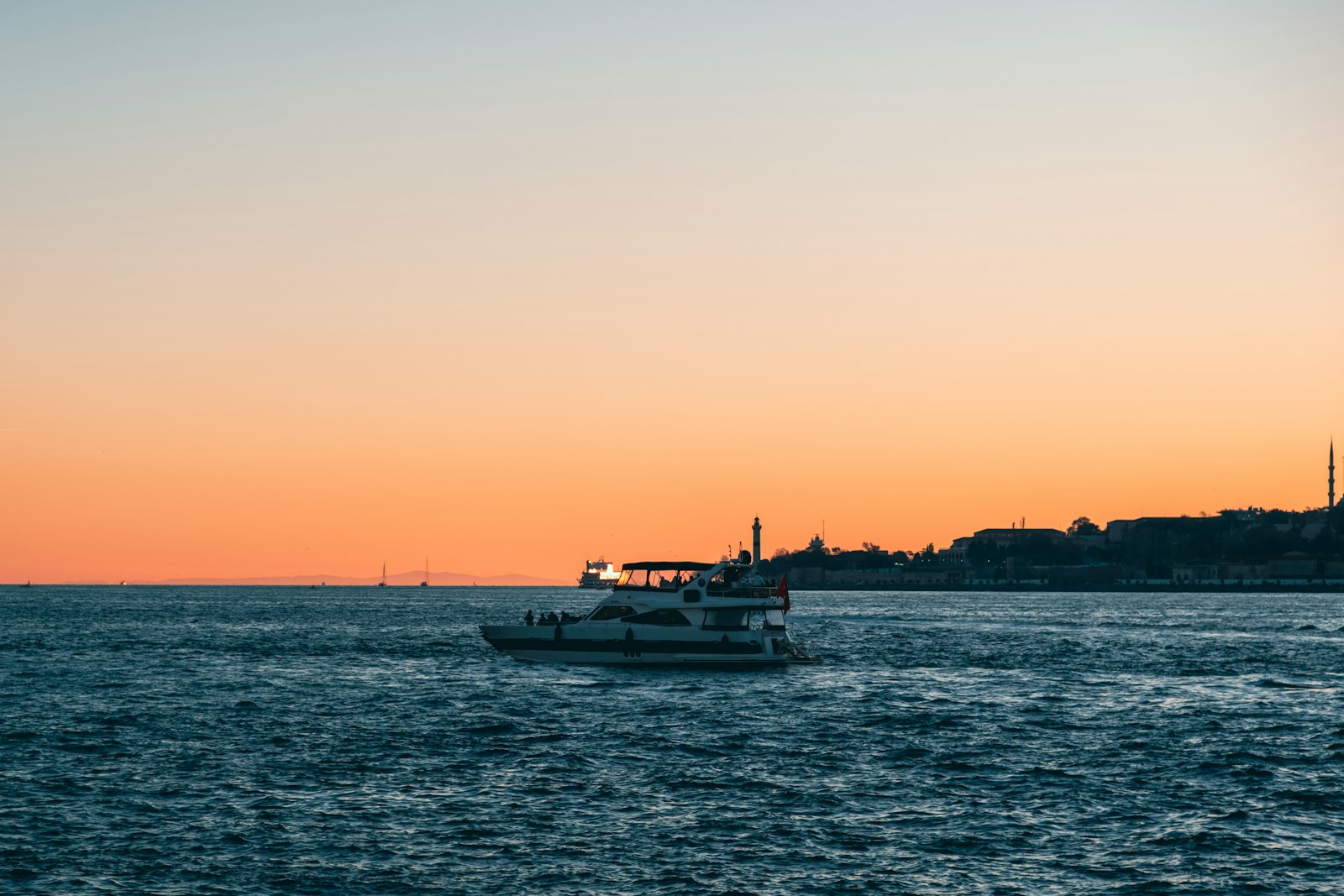 İstanbul silüetine karşı gün batımında motoryat — Boğaz yat turu